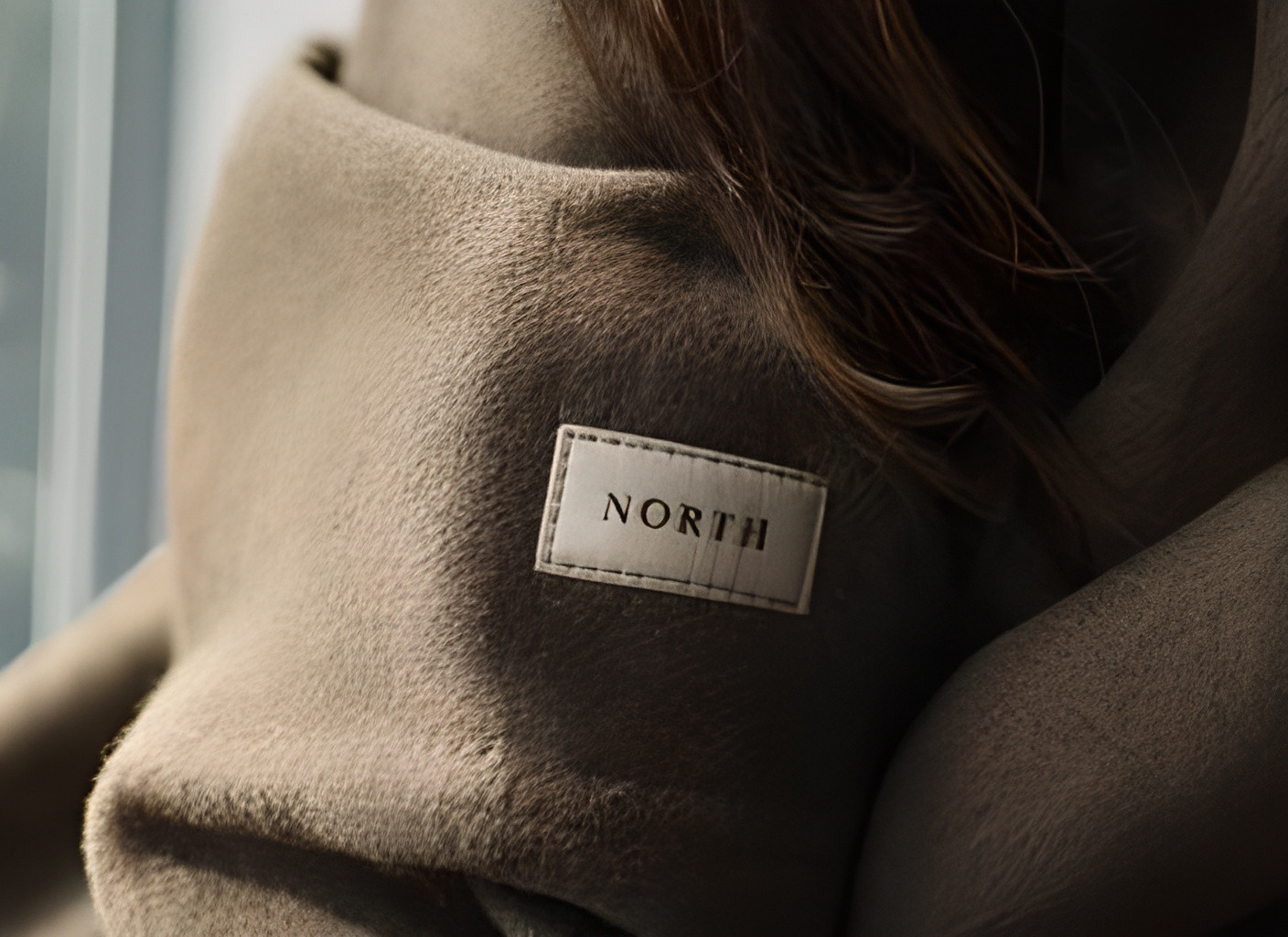 Wool fibers, hair strands, stitching, and a short fabric label